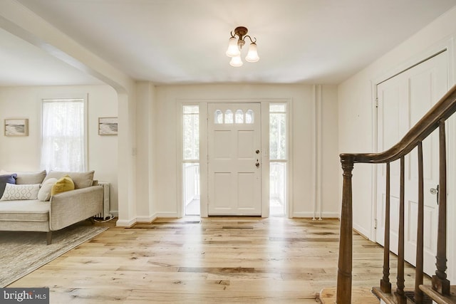 entryway with baseboards and light wood finished floors