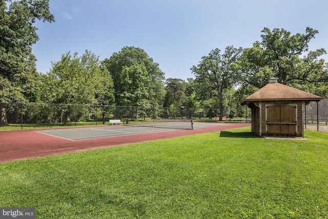 view of sport court with a lawn and fence