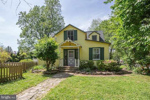 view of front of house with stucco siding, a front lawn, and fence