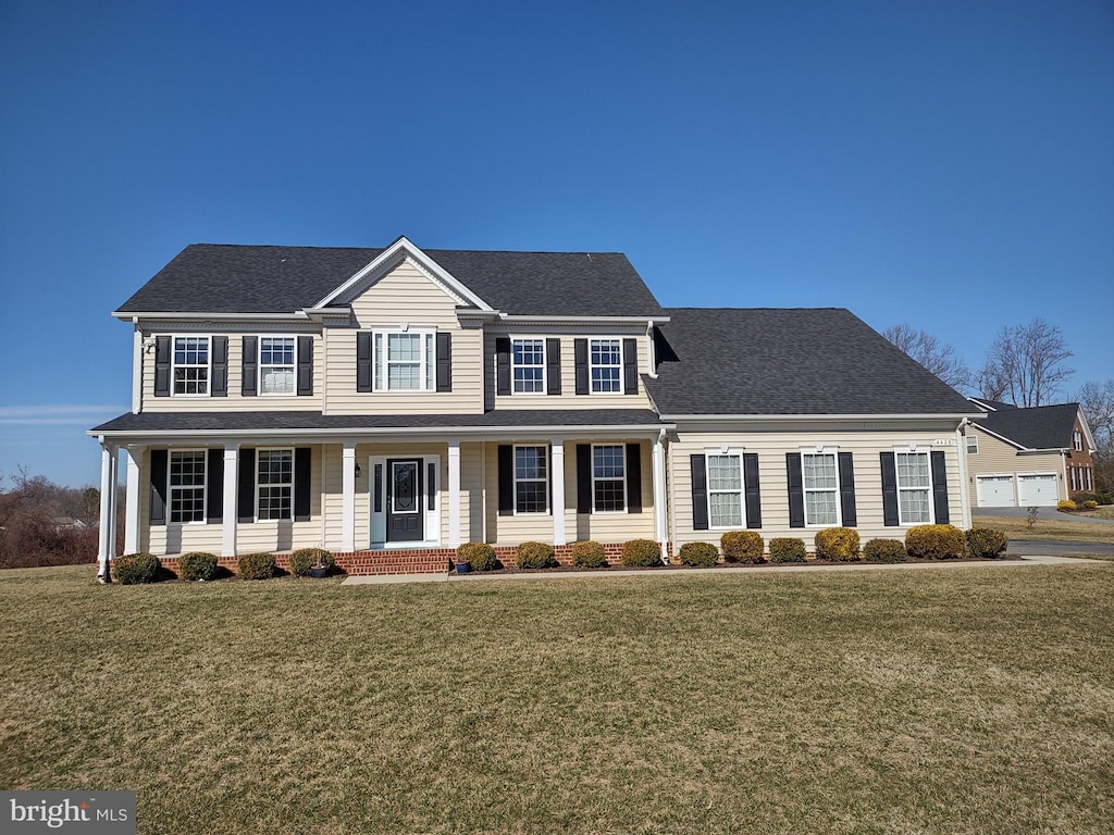 colonial house with a front lawn and roof with shingles