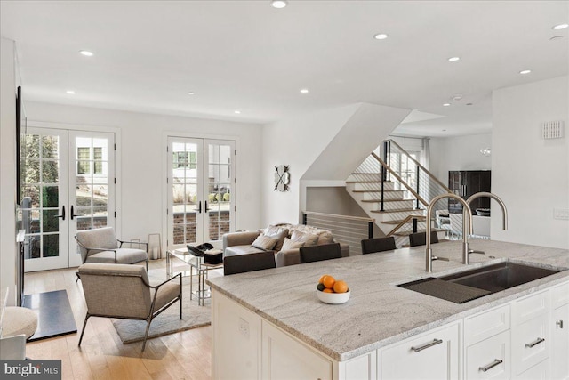 kitchen featuring open floor plan, french doors, and a sink