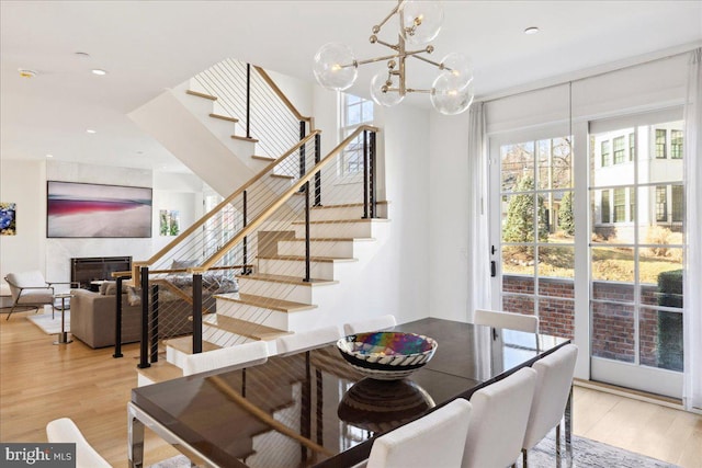 dining room with light wood-style flooring, a fireplace, and a healthy amount of sunlight