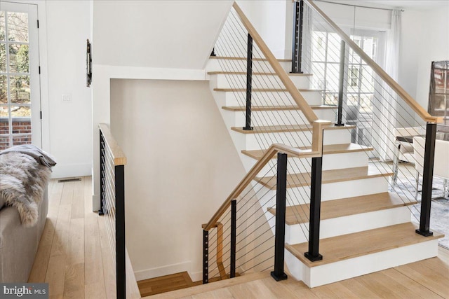 stairs featuring visible vents, baseboards, and wood finished floors