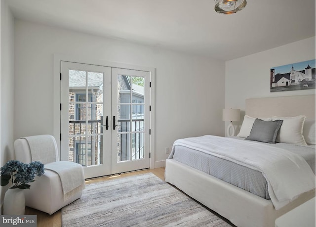 bedroom with access to exterior, french doors, baseboards, and wood finished floors