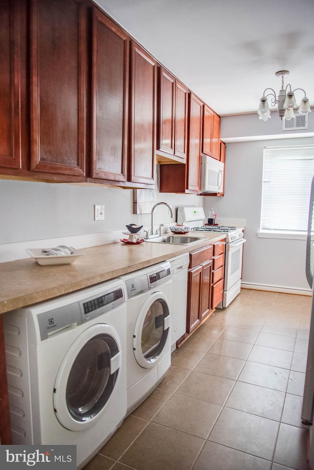 laundry room with washing machine and clothes dryer, visible vents, light tile patterned flooring, a sink, and laundry area