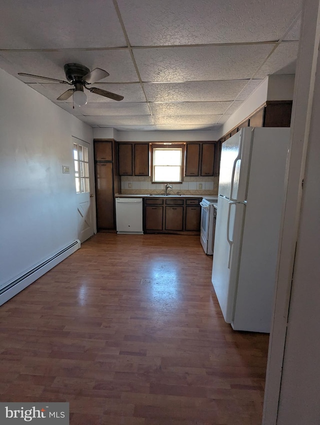 kitchen with white appliances, a baseboard radiator, wood finished floors, and a paneled ceiling