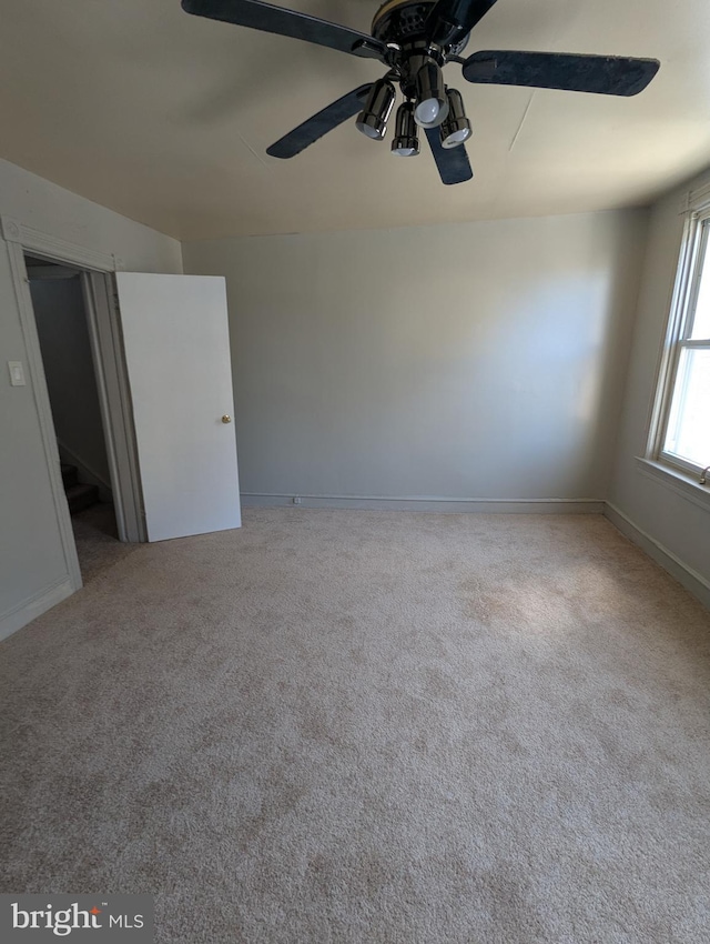 carpeted empty room featuring baseboards