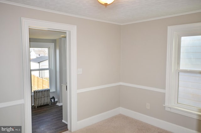 unfurnished room featuring radiator, baseboards, and ornamental molding