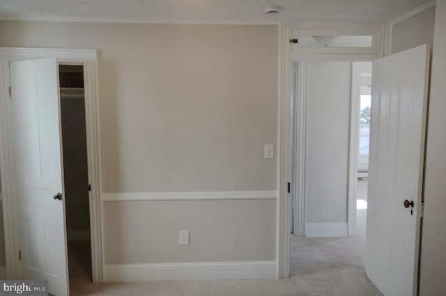 interior space with crown molding, baseboards, and carpet flooring