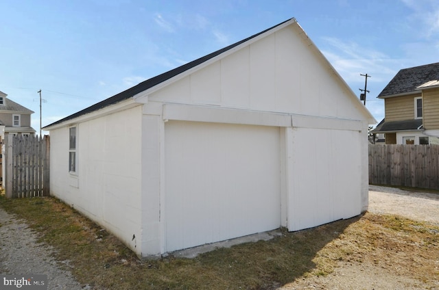 view of side of home with an outbuilding and fence