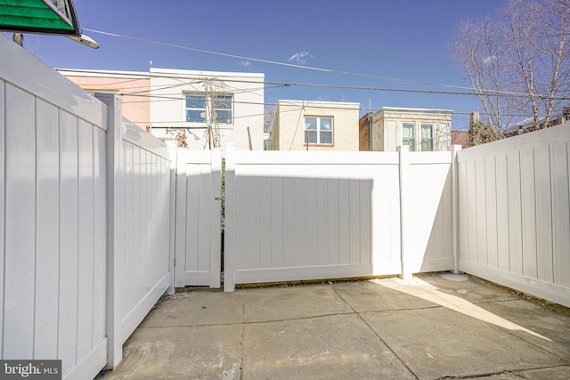 view of gate featuring a fenced backyard and a patio