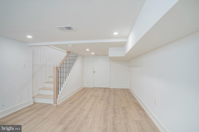 finished below grade area with baseboards, visible vents, stairway, light wood-type flooring, and recessed lighting