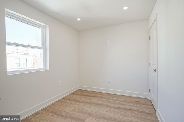 empty room with light wood-type flooring, baseboards, and recessed lighting