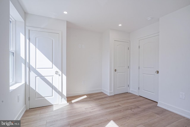 unfurnished room with recessed lighting, baseboards, and wood finished floors