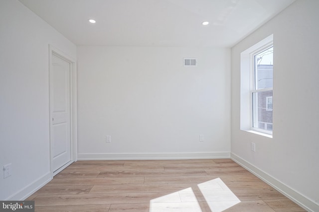 spare room featuring light wood-style floors, recessed lighting, visible vents, and baseboards