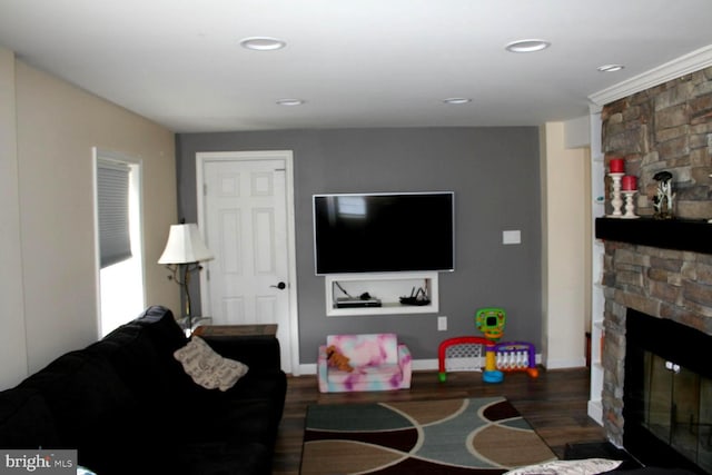 living area with recessed lighting, baseboards, wood finished floors, and a stone fireplace