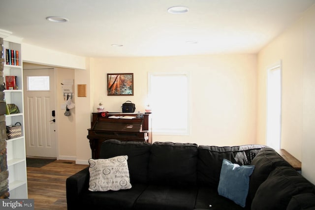 living area with baseboards, recessed lighting, wood finished floors, and a healthy amount of sunlight