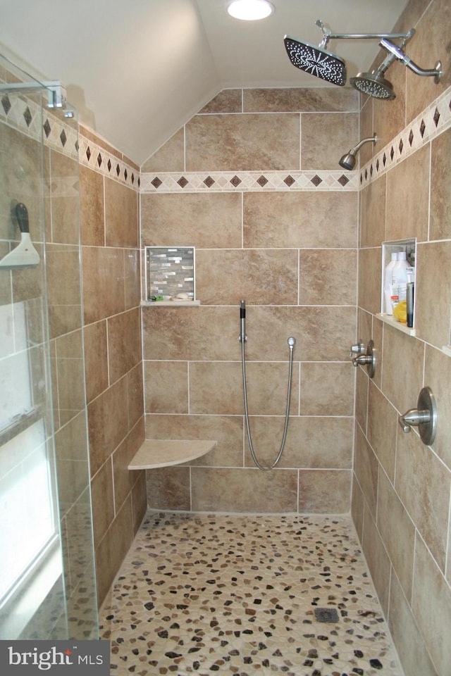 bathroom featuring vaulted ceiling and a stall shower