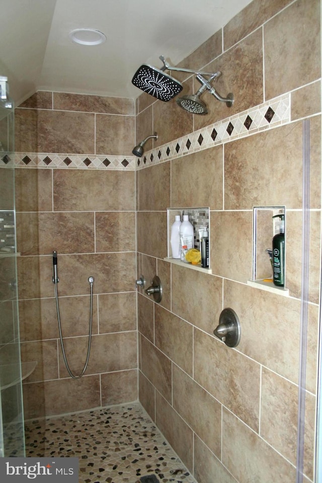 bathroom with lofted ceiling and a stall shower