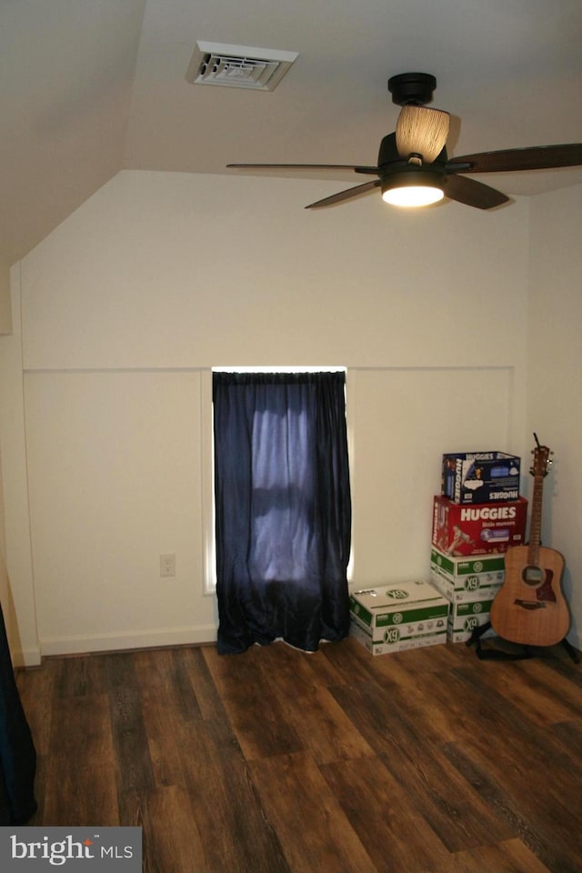 interior space with a ceiling fan, lofted ceiling, visible vents, and wood finished floors