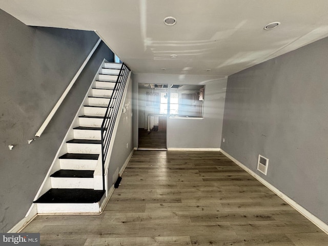 interior space with baseboards, visible vents, and wood finished floors