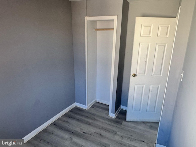 unfurnished bedroom featuring baseboards and wood finished floors