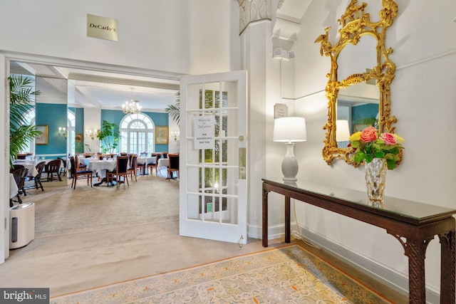 entryway with ornamental molding and a notable chandelier