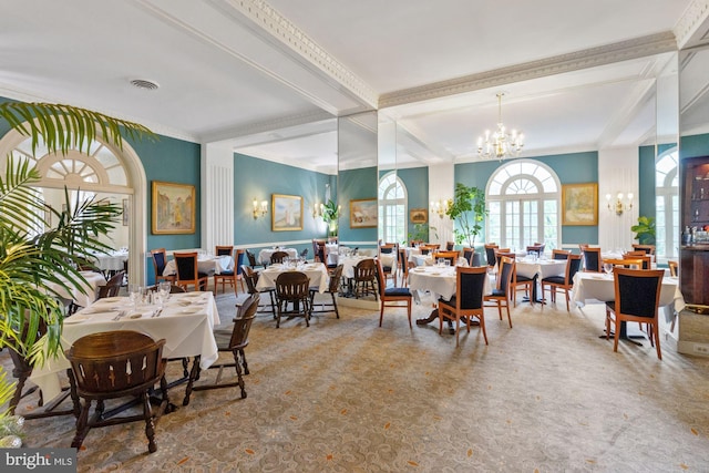 dining space featuring a chandelier, beam ceiling, visible vents, and crown molding