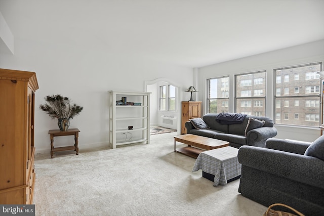 living room featuring a wall unit AC, carpet flooring, and baseboards