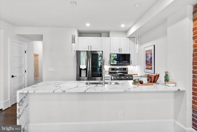 kitchen with white cabinetry, light stone counters, dark wood finished floors, and appliances with stainless steel finishes