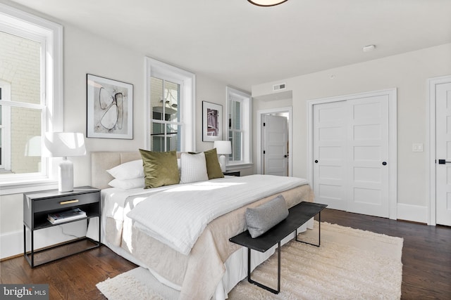 bedroom featuring dark wood finished floors, visible vents, and baseboards