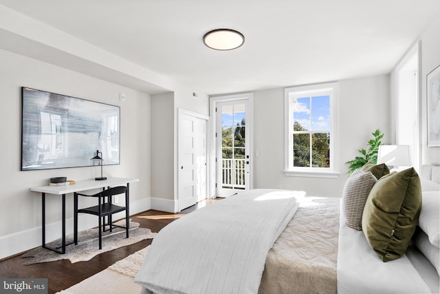 bedroom with baseboards, dark wood-style floors, and access to outside