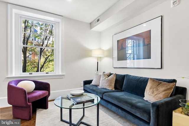 living area featuring visible vents, baseboards, and wood finished floors