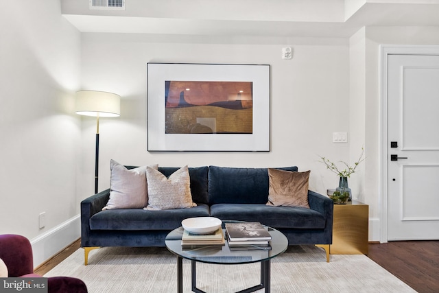 living area featuring wood finished floors, visible vents, and baseboards