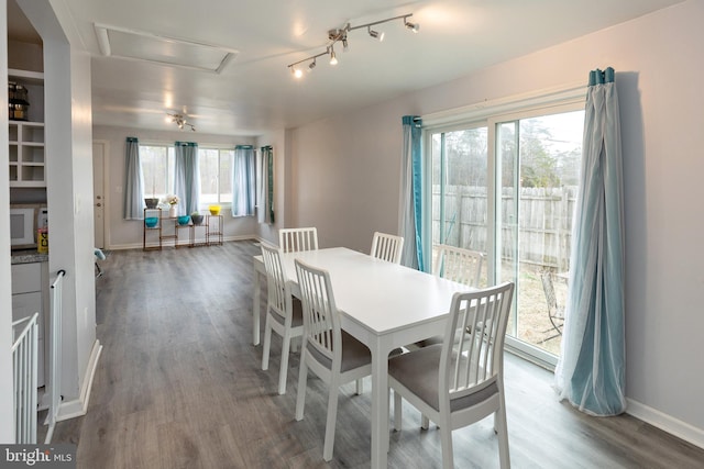 dining room with dark wood-style floors, plenty of natural light, and baseboards