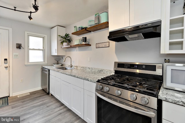 kitchen featuring appliances with stainless steel finishes, under cabinet range hood, white cabinetry, open shelves, and a sink