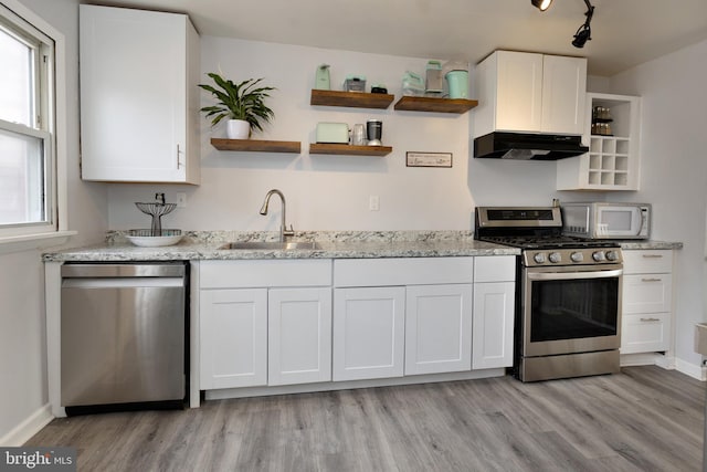 kitchen featuring stainless steel appliances, a sink, white cabinetry, and under cabinet range hood