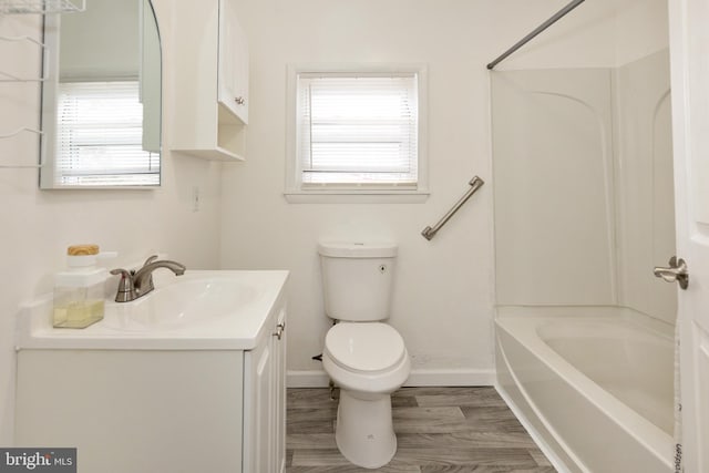 full bathroom featuring toilet, vanity, shower / tub combination, wood finished floors, and baseboards