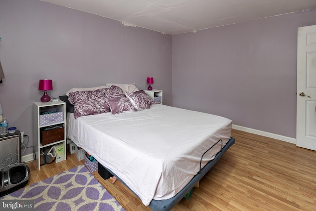 bedroom featuring wood finished floors and baseboards