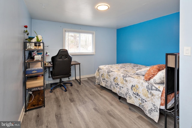 bedroom with baseboards and wood finished floors