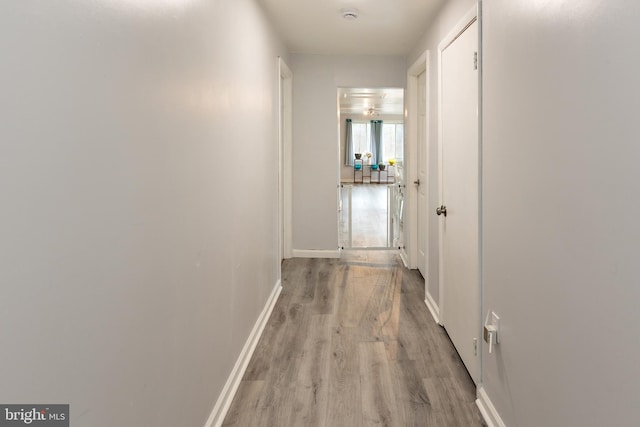 hall featuring wood finished floors and baseboards