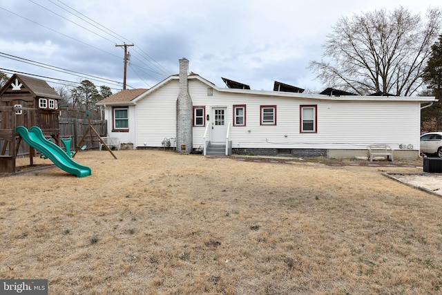 rear view of house with entry steps and a playground