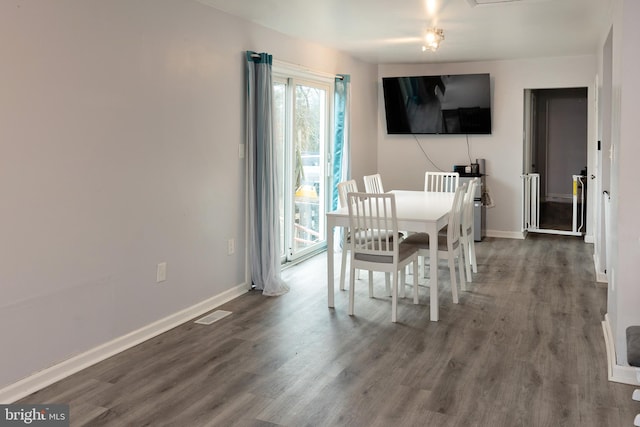 dining room with visible vents, baseboards, and wood finished floors