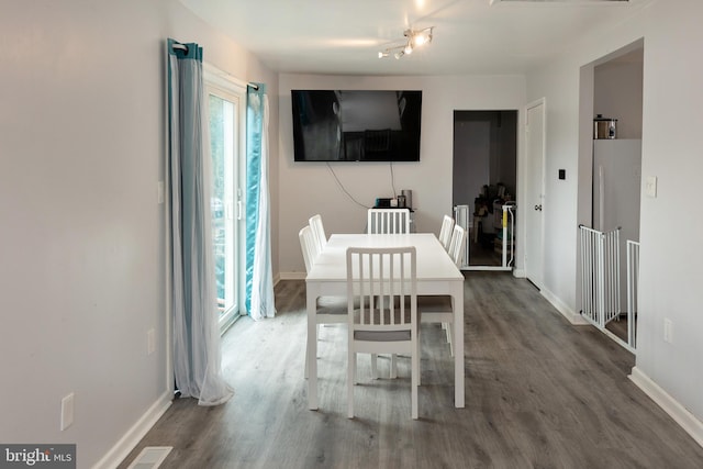 dining room featuring visible vents, dark wood finished floors, and baseboards