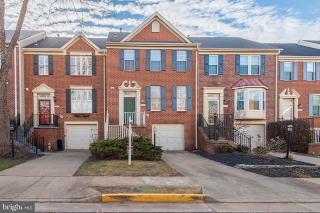 view of property featuring a garage, brick siding, and driveway