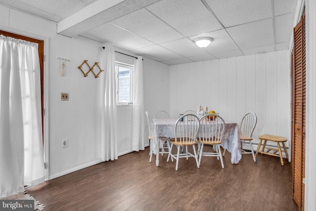 dining area with a paneled ceiling, dark wood-style flooring, baseboards, and baseboard heating