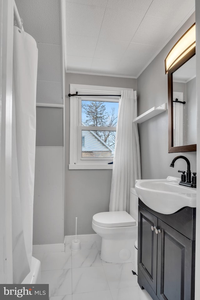 full bath featuring marble finish floor, toilet, ornamental molding, vanity, and a textured ceiling