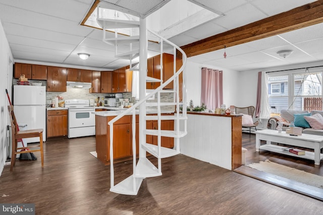 kitchen with white appliances, open floor plan, dark wood-style flooring, a peninsula, and light countertops