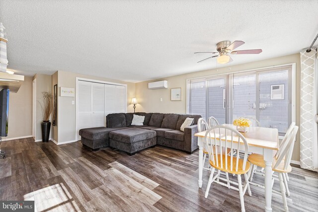 5909 Ocean Blvd, Long Beach Township, NJ 08008 - living room featuring a textured ceiling, an AC wall unit, baseboards, and wood finished floors