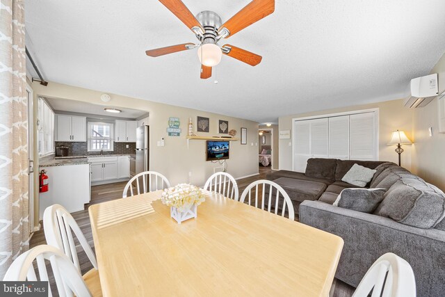 5909 Ocean Blvd, Long Beach Township, NJ 08008 - dining room featuring an AC wall unit, ceiling fan, and wood finished floors